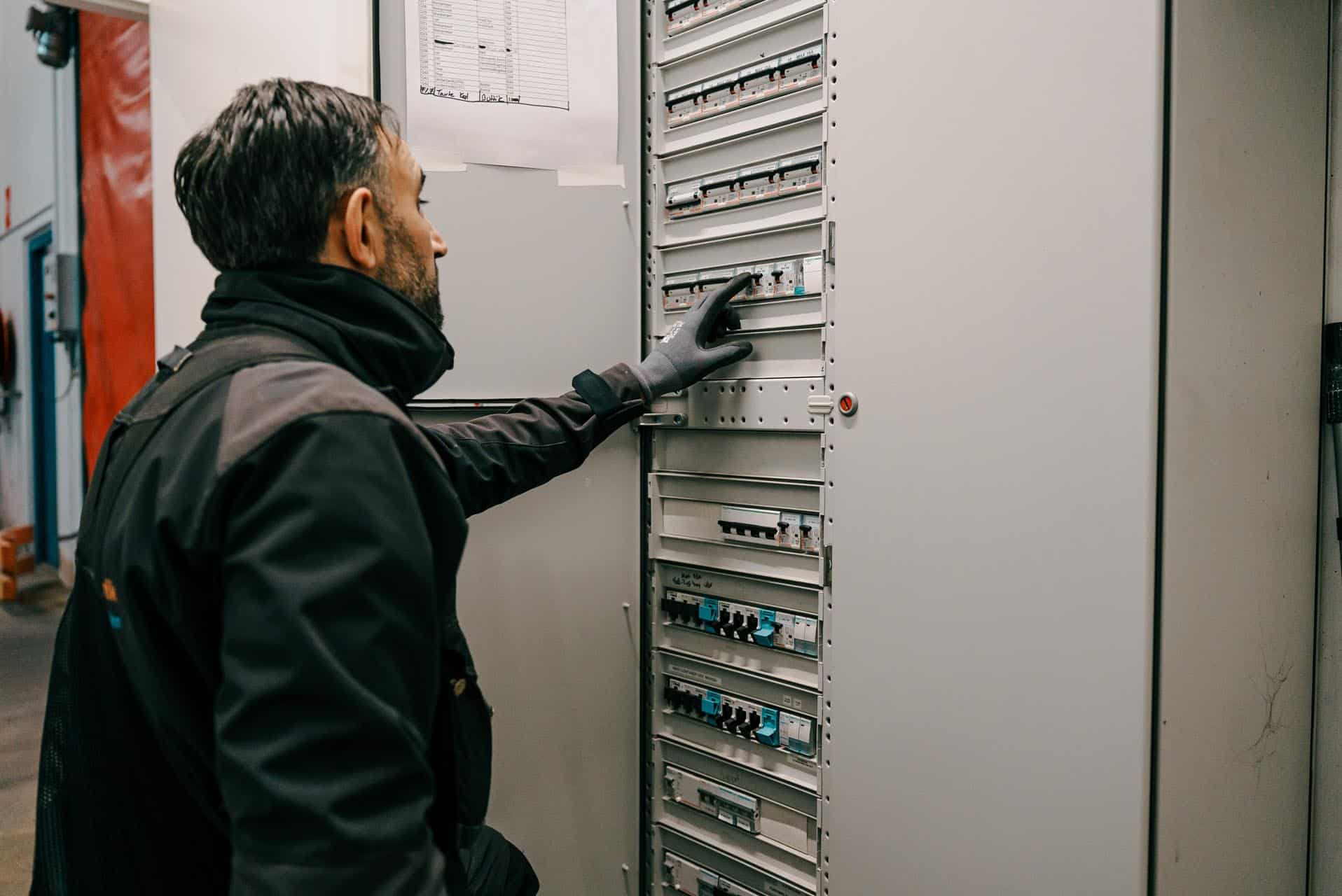 Elektriker arbejder ved eltavle